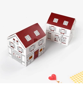 Detailed view of two white and red house-shaped paper gift boxes for bakery and sweets