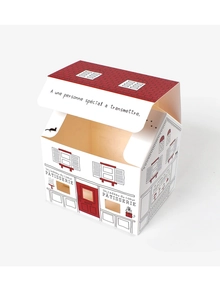 Detail view of a white house-shaped pastry box with red roof and artistic sketches
