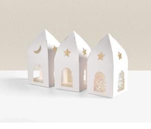 Détail de boîtes cadeaux blanches en forme de maison avec découpes d'étoiles et lune