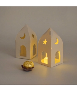 Détail boîte cadeau en papier ajouré avec étoiles et lune éclairée par bougie LED