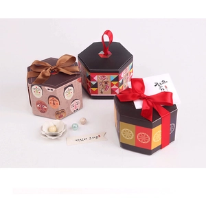 Tre scatole regalo esagonali con motivi tradizionali e decorazioni in nastro