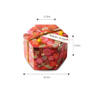 Scatola regalo esagonale rossa con motivi floreali e nodi dorati per matrimoni