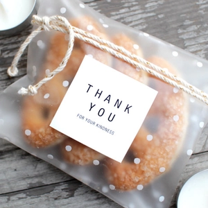 Polka dot frosted gift bags with square thank you stickers and twine for baking treats