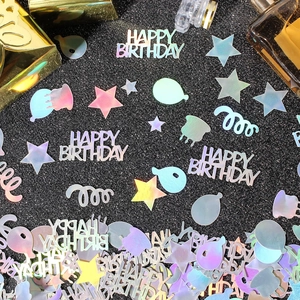 Macro shot of laser holographic happy birthday confetti with stars and balloon shapes