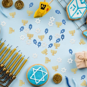 Close-up of sparkling Hanukkah confetti with Star of David and Menorah shapes on blue background