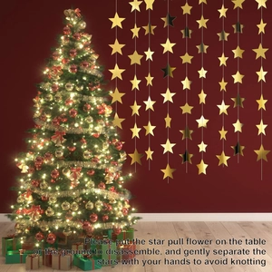 Detail of shiny gold star garland hanging next to a decorated Christmas tree in festive scene