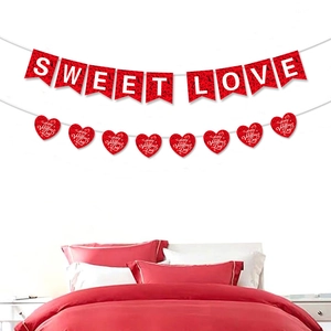 Detail der roten Sweet Love Girlande und Happy Valentine's Day Herzen über dem Bett