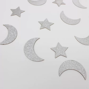 Macro shot of silver glitter moon and star confetti for festive party table decorations