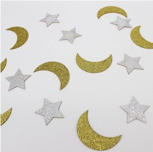 Macro detail of glitter star and moon confetti for festive party table decoration