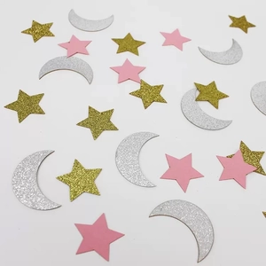Macro detail of glitter star and moon confetti in gold, silver, and pink cardstock