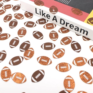 Close-up of brown glitter and smooth football confetti for sports party decorations