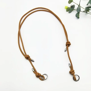 Detail of adjustable caramel leather strap with polished silver ring and knot design