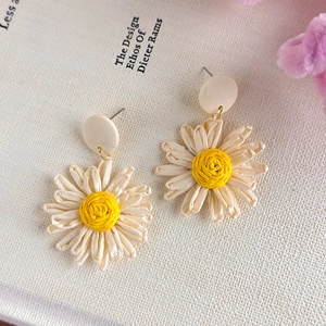 Handmade woven daisy drop earrings with white petals and yellow centers for summer beach vacation