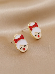 Gros plan de boucles d'oreilles fille avec strass rouges sur fond de satin champagne