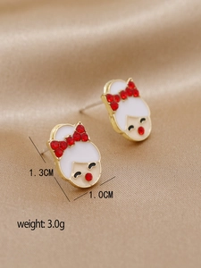 Gros plan de boucles d'oreilles fille avec nœud en cristal rouge sur satin doré