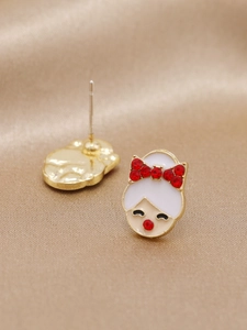 Détail de boucles d'oreilles fille avec nœud en cristal rouge sur fond satin champagne