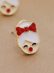 Gros plan de boucles d'oreilles fille avec nœud en strass rouge et émail blanc sur alliage