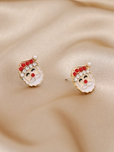 Vue macro de boucles d'oreilles Père Noël avec émail rouge et strass brillants
