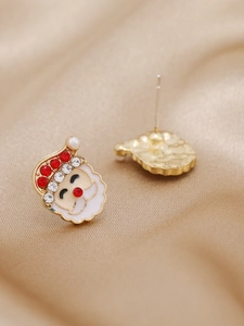 Vue macro des boucles d'oreilles Père Noël avec strass rouges et perles blanches