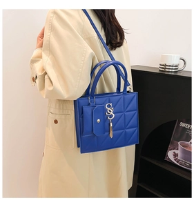 Dettaglio borsa blu reale in pelle trapuntata con logo S dorato e mini astuccio laterale