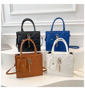 Borse tote trapuntate in nero, blu, marrone e bianco con nappine in metallo e mini pochette