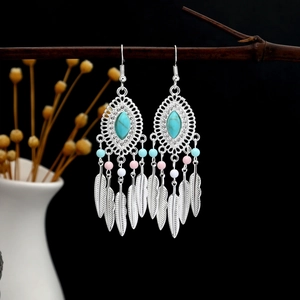 Detail of bohemian silver feather earrings with turquoise stone and colorful beads
