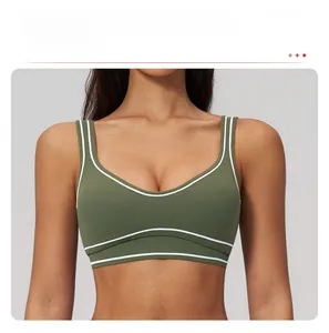 Detail of olive green sports bra with white contrast piping and U-neckline design