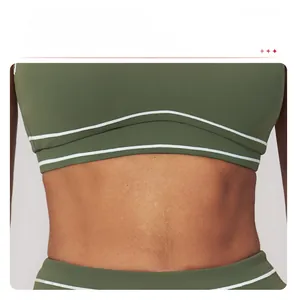 Detail showing wide hem design of olive green sports bra with dual white stripes