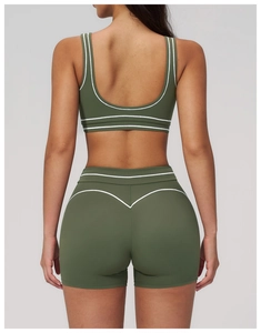 Detail of deep green yoga set featuring white contrast lines and V-shape push-up shorts