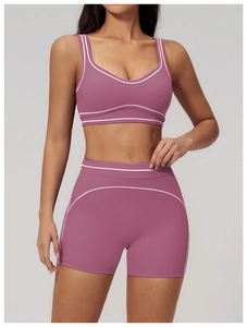 Detail of dusty pink yoga bra and high-waist shorts set with white trim accents