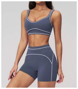 Detail of grey-blue yoga set showing contrast white stitching and matte stretch fabric