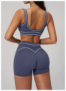 Rear view of high-waist fitness shorts with V-shaped contour lines and white piping detail