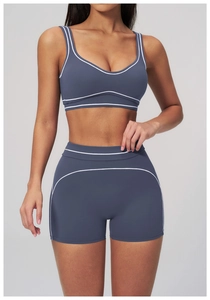 Close-up of gray-blue yoga set featuring contrasting white piping and elastic sports fabric