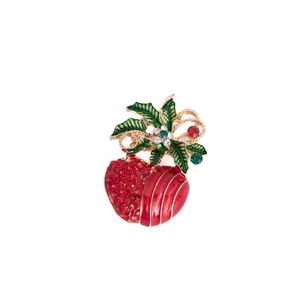 Close-up of Christmas heart brooch with red rhinestones and green holly leaves detail