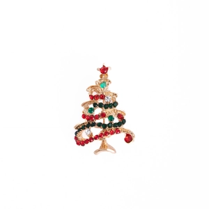 Close-up of golden Christmas tree brooch with colorful rhinestones and red star gem