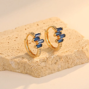 Detailed shot of vintage gold-plated hoop earrings with rectangular blue zircon stones