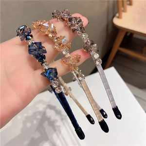 Close-up of luxury crystal floral headbands in navy, champagne, and grey purple colors
