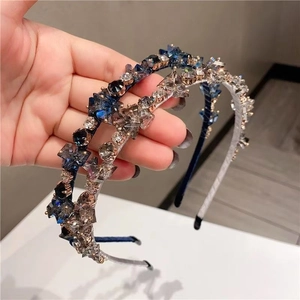 Detailed view of two handmade luxury crystal headbands in navy blue and translucent grey