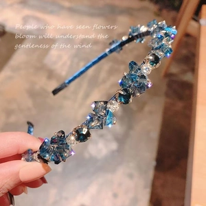 Close-up of blue crystal rhinestones on a slim luxury headband with silver accents