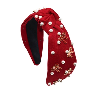 Elegante cerchietto in tessuto rosso annodato con perle bianche e fiocco in smalto rosso