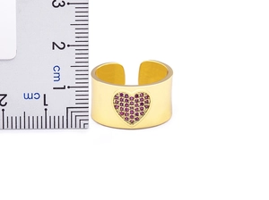 Close-up of 1.2cm wide gold-plated heart ring with pink stones beside a scale ruler