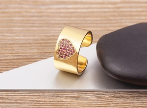 Detail of 18K gold plated wide open ring featuring a heart set with purple zircons