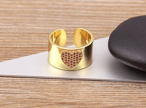 Macro detail of 18K gold plated wide ring featuring a pink zircon pavé heart charm
