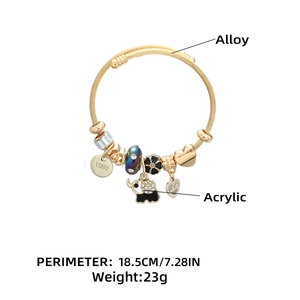 Detailed view of golden charm bracelet with elephant, heart, and floral pendants