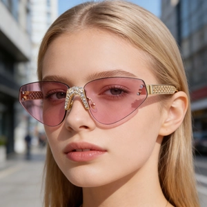 Gros plan de lunettes de soleil œil-de-chat roses sans monture avec branches dorées strass