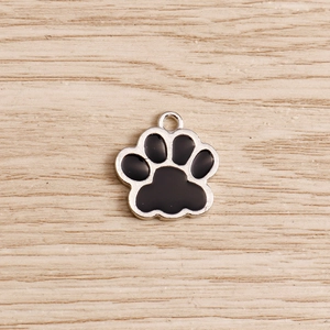 Macro detail of silver alloy cat paw charm with black enamel for DIY jewelry making