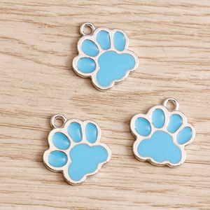 Close-up of three blue enamel cat paw charms with silver metal edges for DIY jewelry