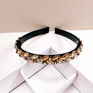 Elegant crystal headband with champagne marquise stones on black base on white pedestal
