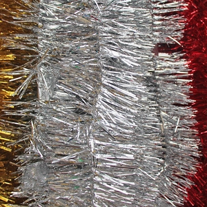 Close-up of sparkling Christmas tinsel garlands in gold, silver, and red metallic finishes