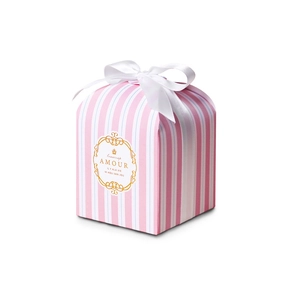 Detail of pink and blue striped gift box featuring a white ribbon bow and gold accents